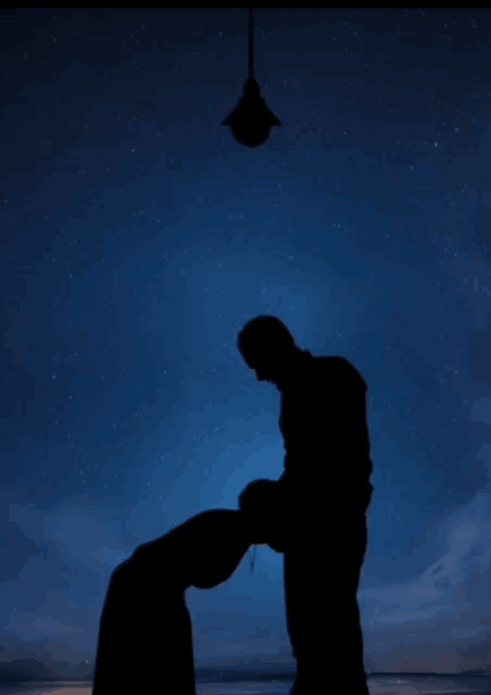 a man and woman kissing a little girl while a light bulb shines above them