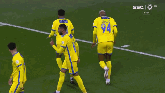 soccer players wearing yellow jerseys with the number 11 and 94