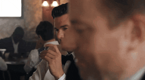 a man in a tuxedo is smoking a cigar