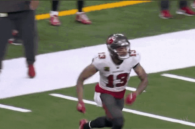 a football player is running on the field with the ball .