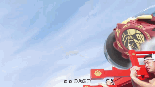 a man in a red headband is holding a red object with chinese writing on it