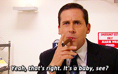 a man in a suit and tie is smoking a cigar and says yeah that 's right it 's a baby