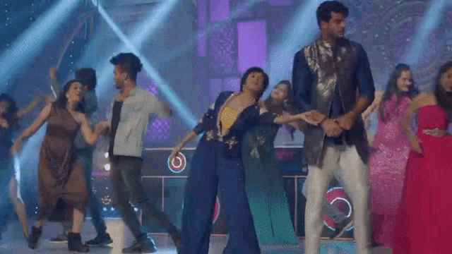 a group of people are dancing on a stage in front of a purple background .