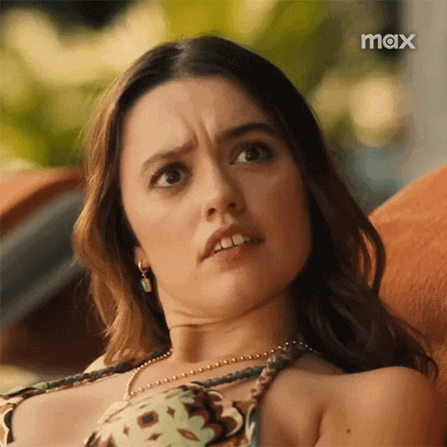a woman in a bikini is making a funny face while sitting in a chair .