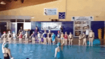 a group of people are standing in a pool holding hands