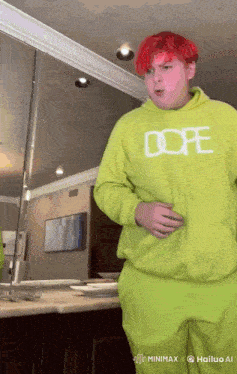 a man with red hair is wearing a green hoodie that says dope