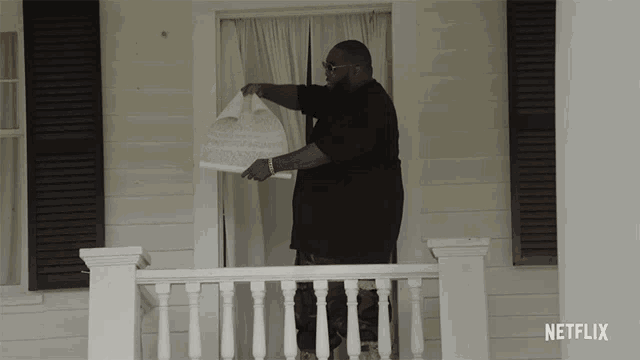 a man standing on a porch with a netflix logo on the bottom right