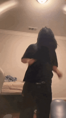 a woman with long hair is dancing in a room