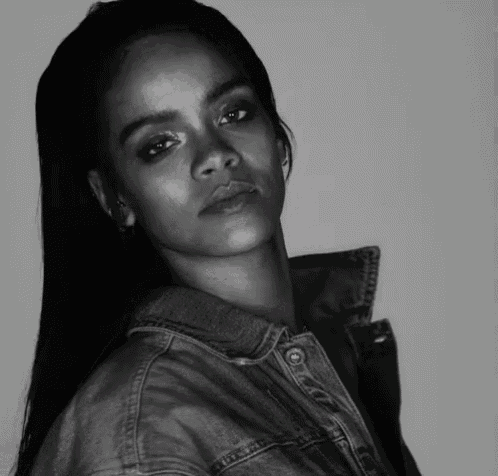 a black and white photo of a woman wearing a denim jacket and earrings