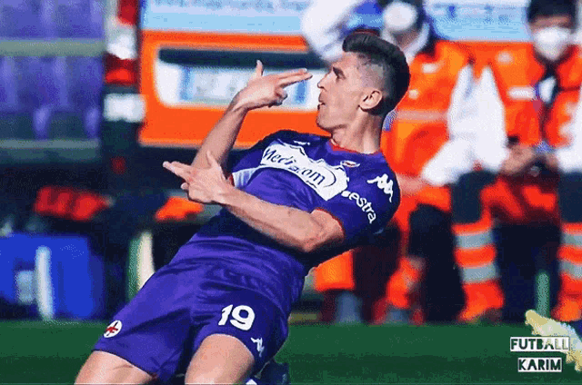 a soccer player in a purple jersey with the number 19 on it