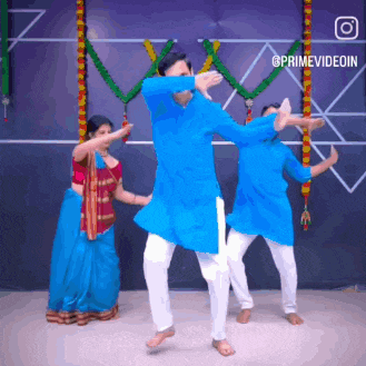 a man in a blue shirt is dancing in front of a woman