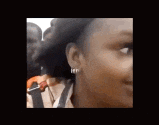 a close up of a woman 's face with a group of people behind her