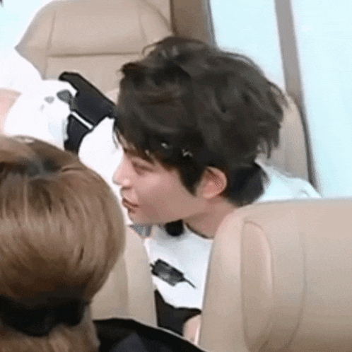 a man is sitting in a chair talking to another man on a plane .