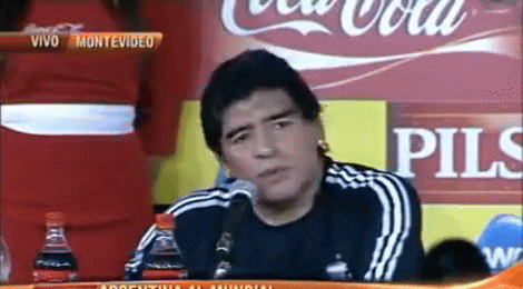 a man is sitting in front of a coca cola ad