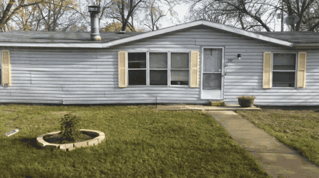 a white mobile home with yellow shutters and a walkway