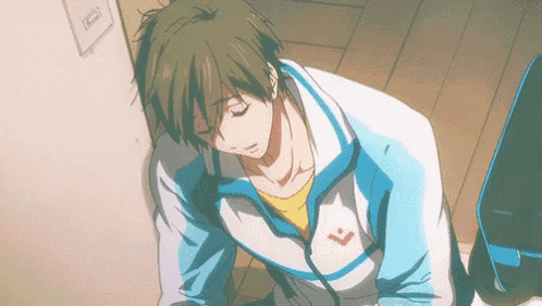 a man in a blue and white jacket with a red arrow on the back is laying down on the floor .