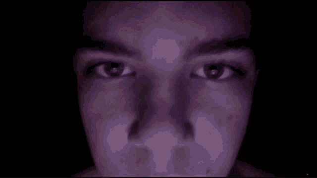 a close up of a person 's face with a dark background