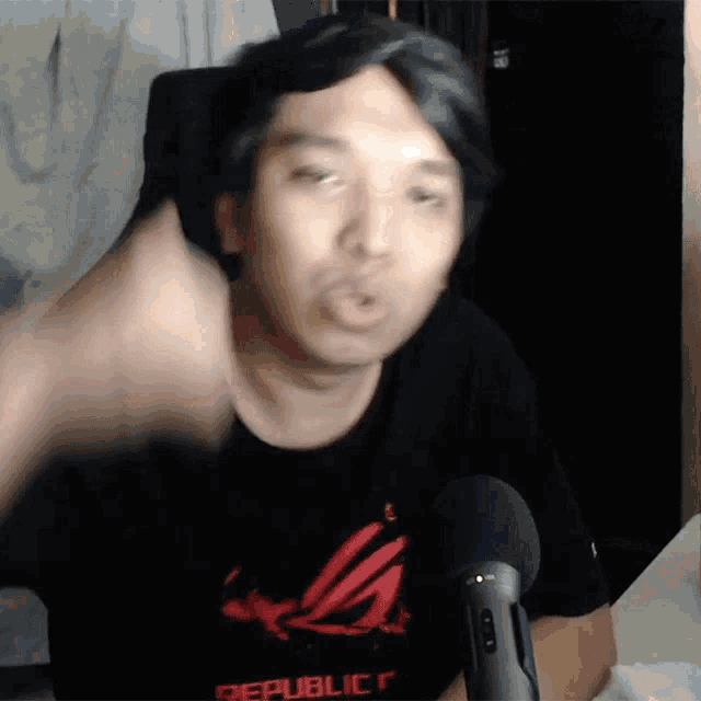 a man wearing a republic t-shirt is making a face
