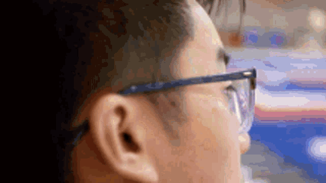 a close up of a man wearing glasses looking at something .