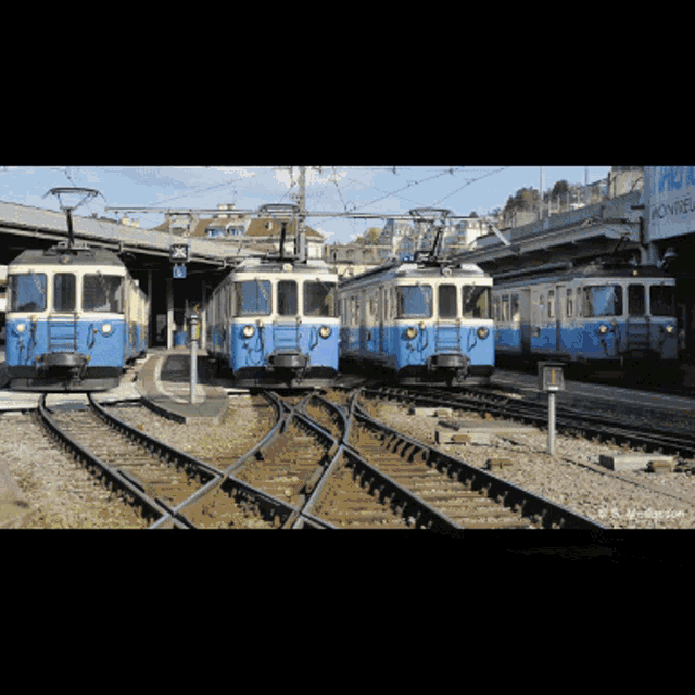 a row of blue and white trains are lined up on a train track