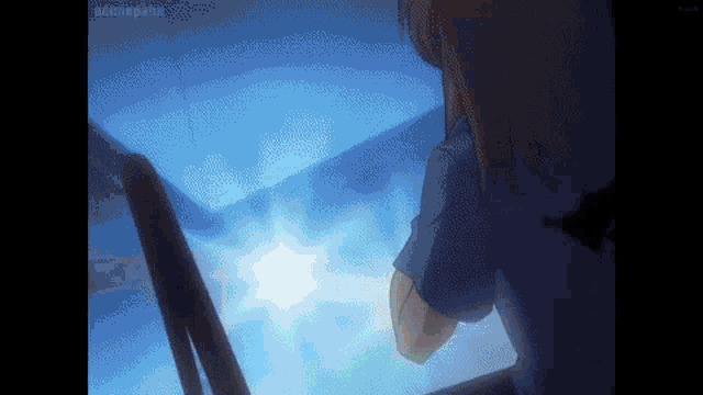 a girl in a blue shirt is standing in front of a window looking out at the sun .