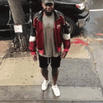 a man is standing on a sidewalk in front of a truck