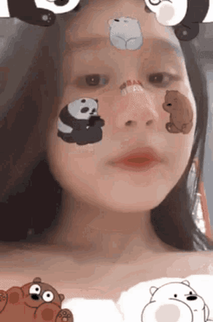 a girl with stickers on her face including panda bears and ice bears .