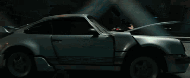 a silver porsche is driving down a road