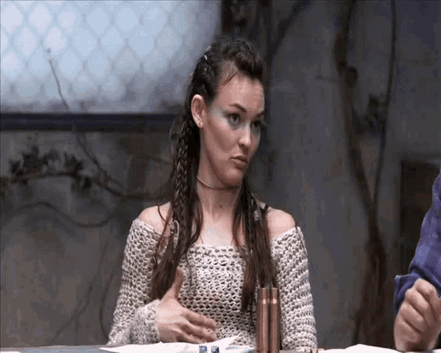 a woman in a knitted sweater is sitting at a table with a man