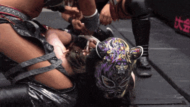 a woman in a purple mask is laying on the floor