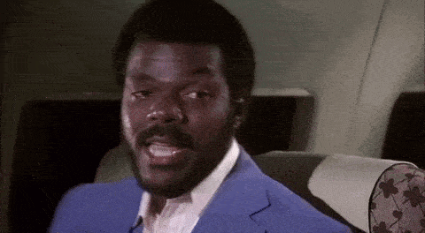 a man in a blue suit and white shirt is sitting on an airplane .