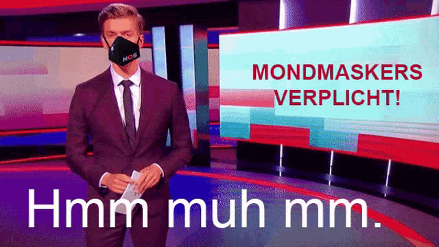 a man in a suit and tie is standing in front of a screen that says mondmaskers verplicht