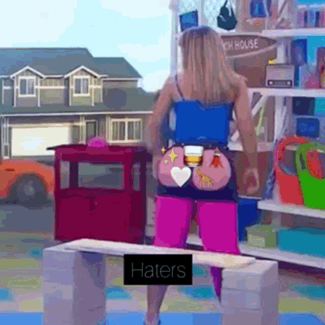 a woman is standing on a bench with a sign that says haters on it