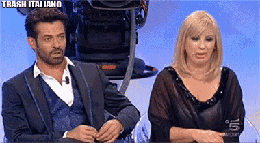 a man in a suit and a woman in a black dress are sitting next to each other in front of a camera ..