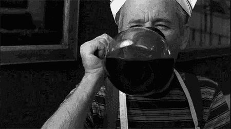 a black and white photo of an elderly man wearing a chef 's hat .