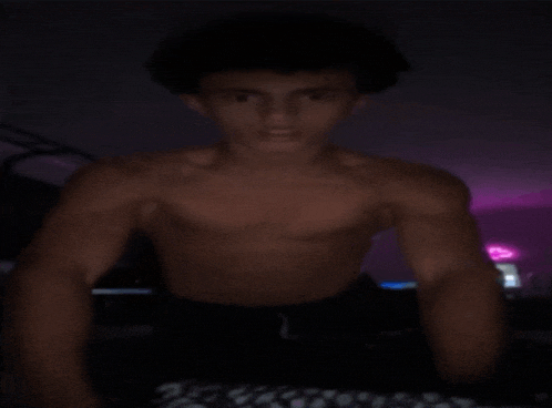 a man without a shirt is doing push ups in the dark