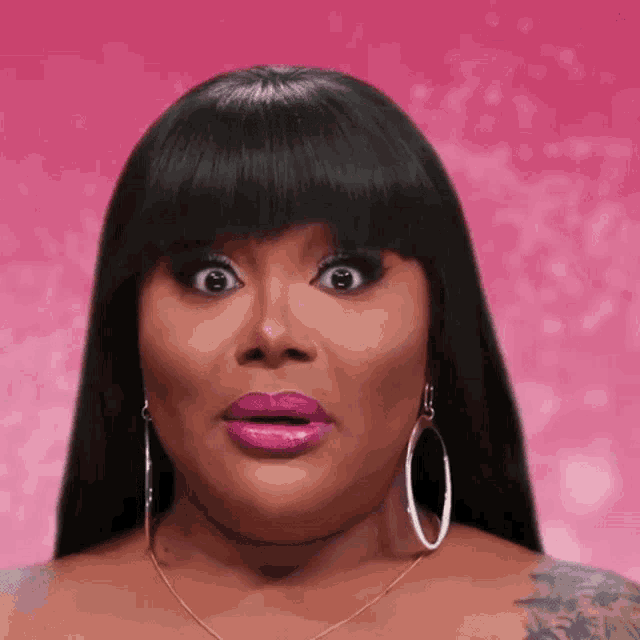 a woman with a tattoo on her arm is wearing hoop earrings and a necklace