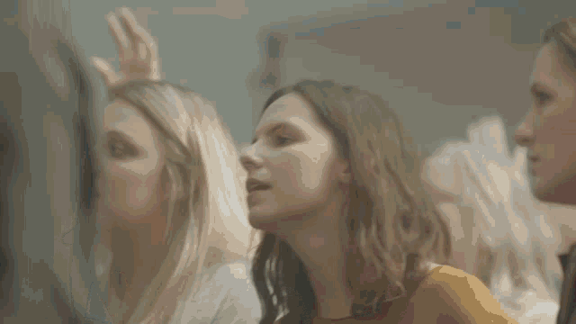 a group of women sitting in a room with their hands up