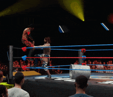 a man in a wrestling ring with a trash can in front of him