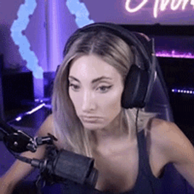 a woman wearing headphones and a microphone is sitting in front of a microphone .