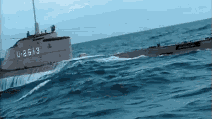 a submarine with the number u-2613 on it is floating on top of a body of water .