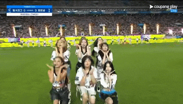 a group of cheerleaders are performing on a soccer field with a coupang play advertisement in the corner