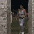 a woman in pajamas is walking through a doorway