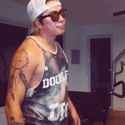 a man wearing sunglasses and a tank top that says double t on it