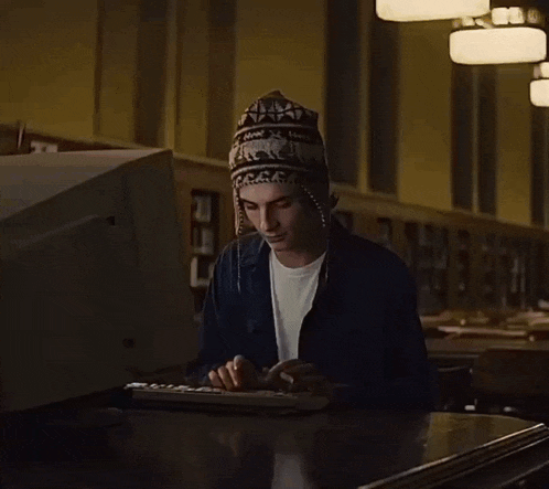 a person wearing a hat is typing on a keyboard