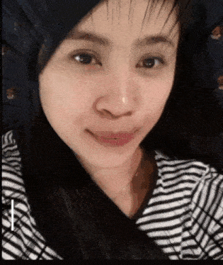 a close up of a woman 's face with a striped shirt