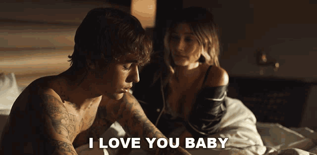 a man and a woman are laying on a bed and the man is saying i love you baby