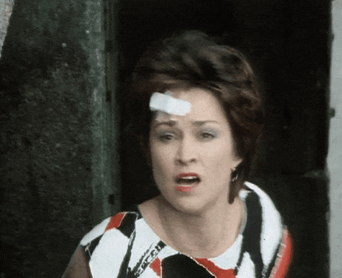 a woman with a bandage on her forehead is wearing a zebra print dress