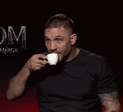 a man drinking from a white cup with the word carnage behind him