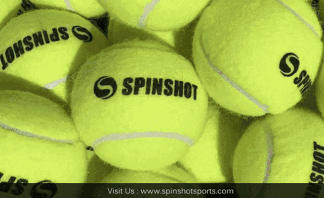 a bunch of yellow tennis balls with spinshot written on them